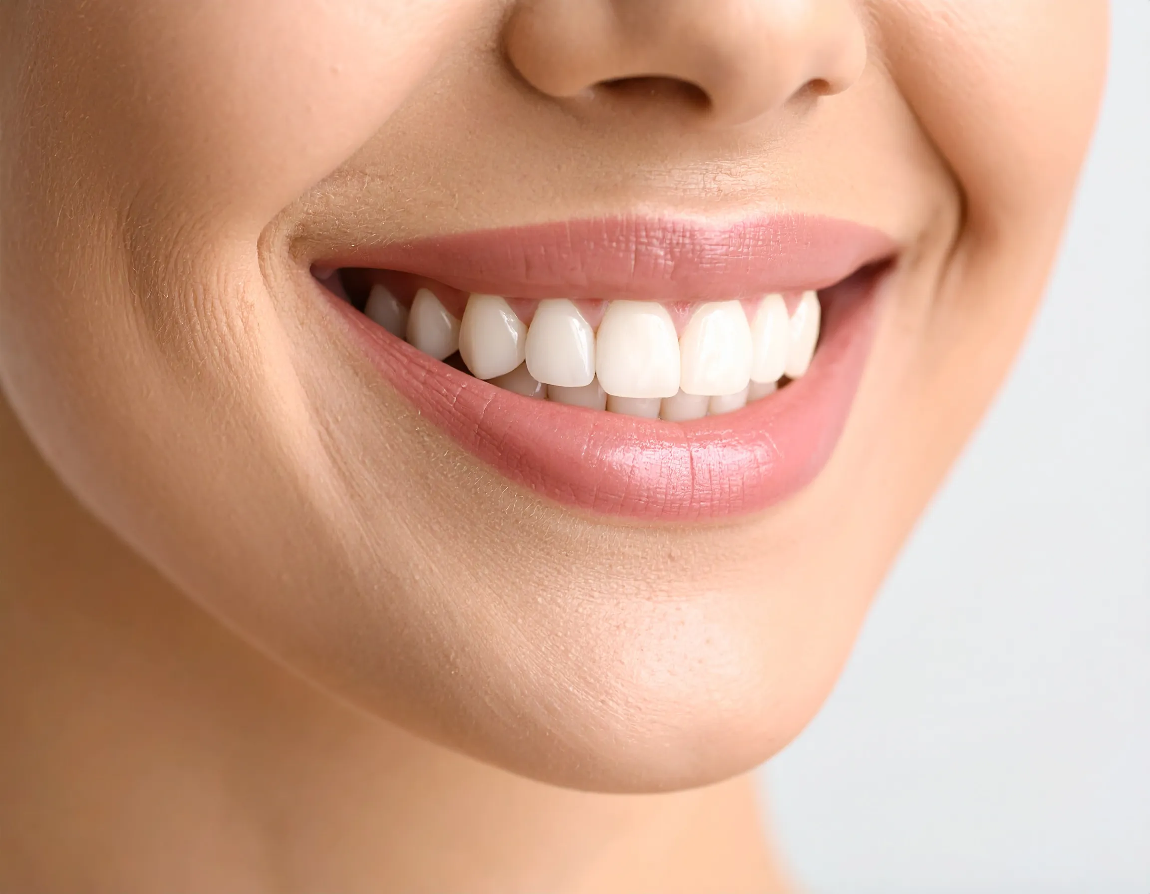 Illustration av ett skinande leende med vita tänder.