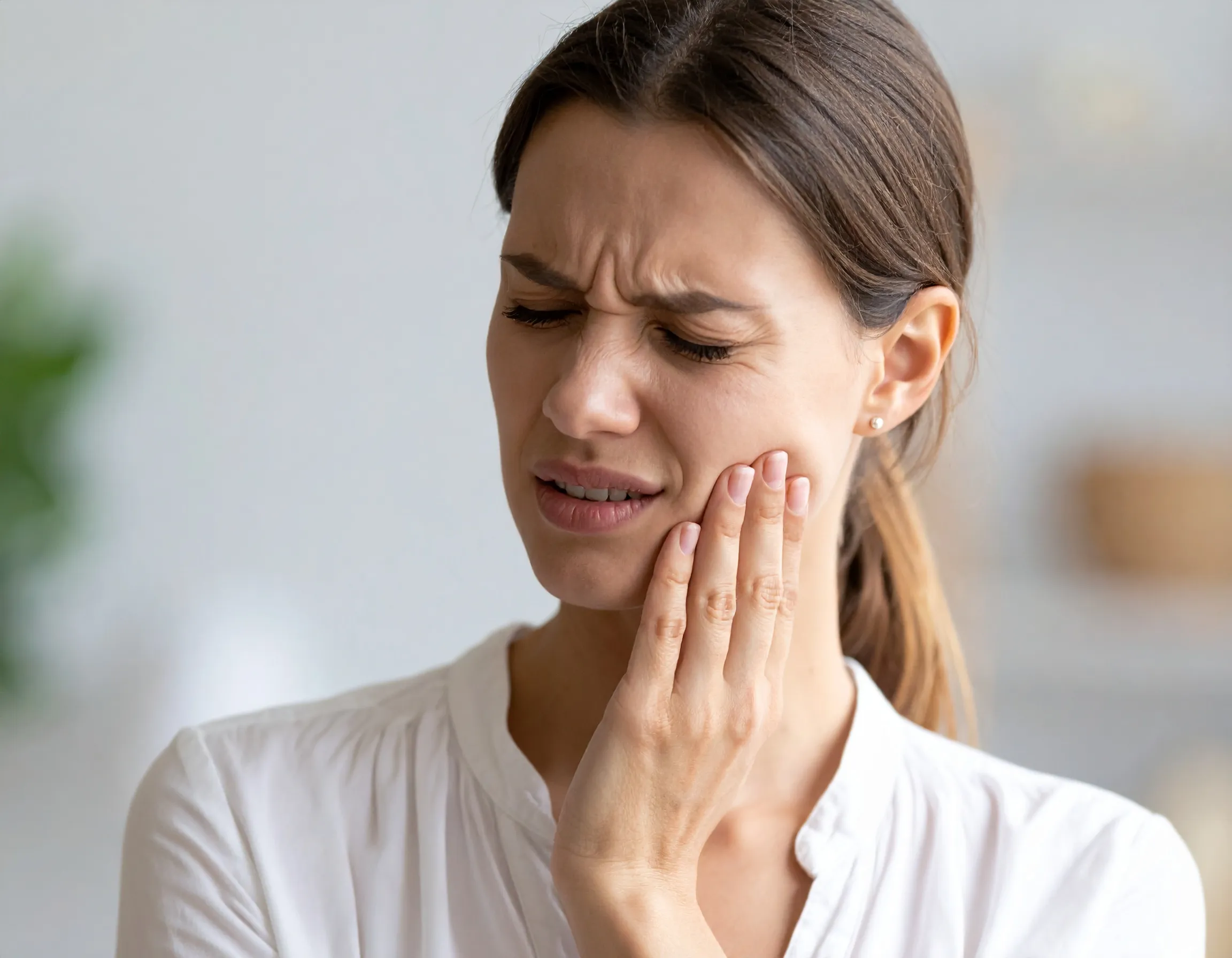 Illustration av en visdomstand som orsakar problem och värk i käken hos en kvinna.