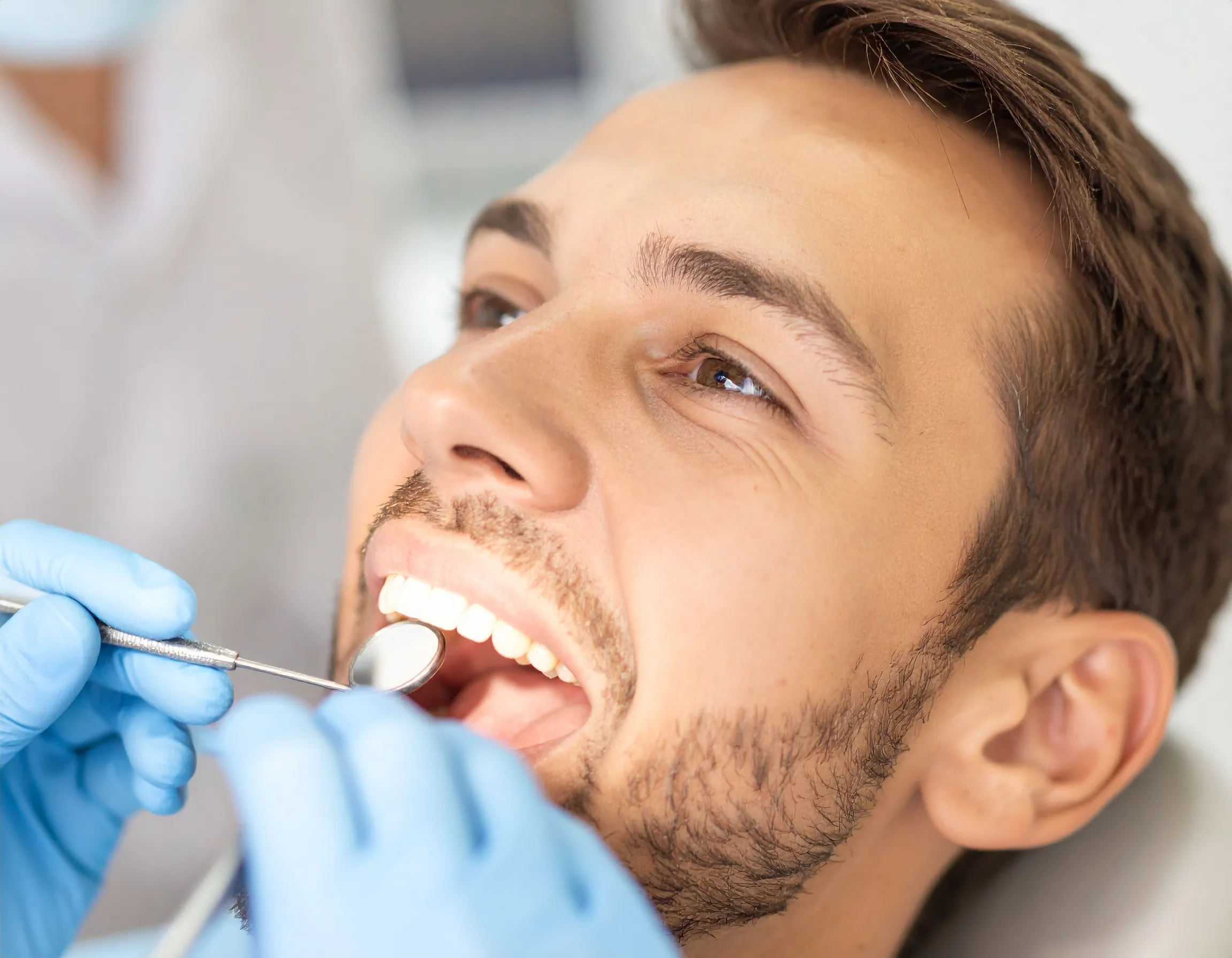 Tandläkare som genomför en tandundersökning på en patient.