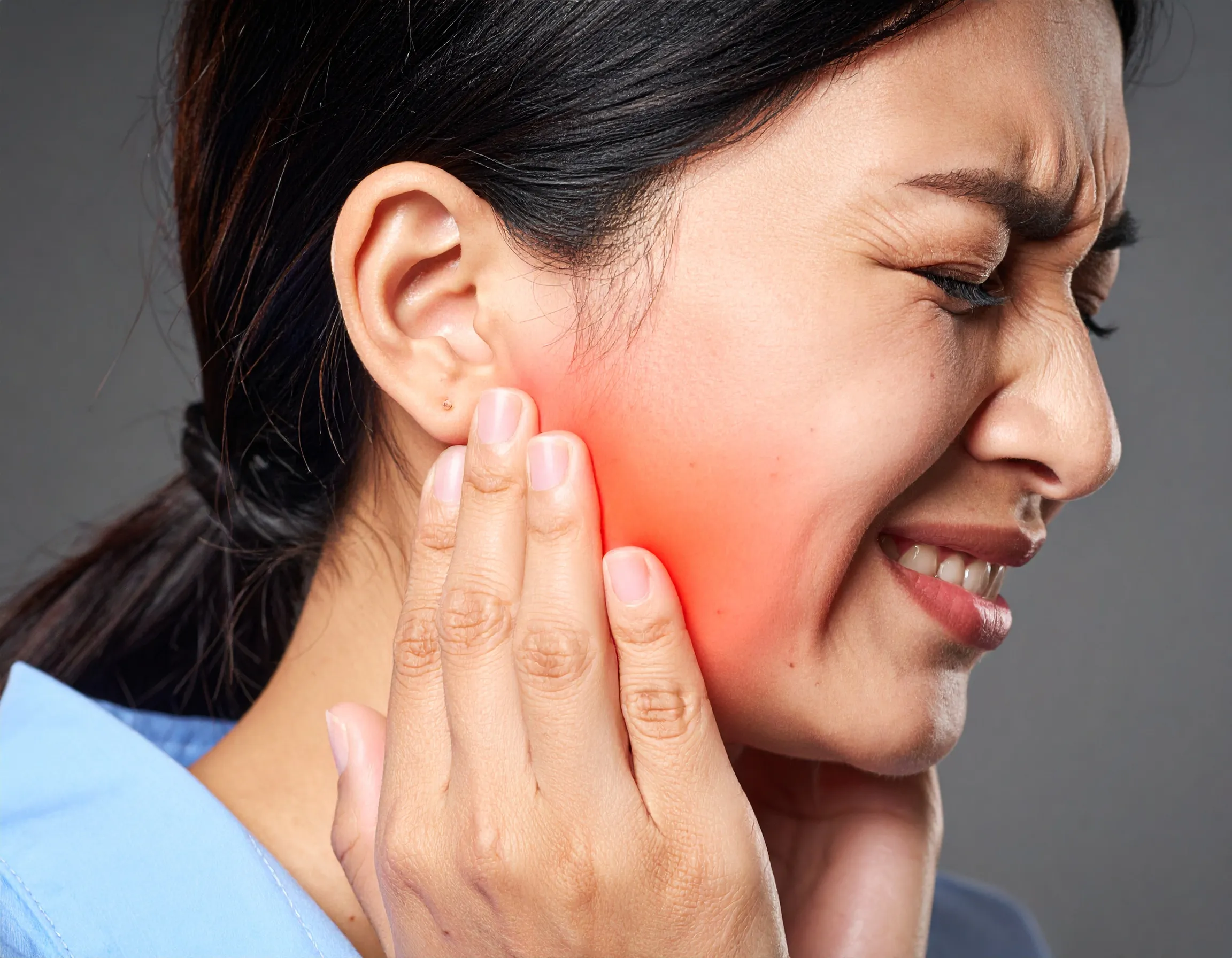 En kvinna som har ont i käkleder och käkmuskler
